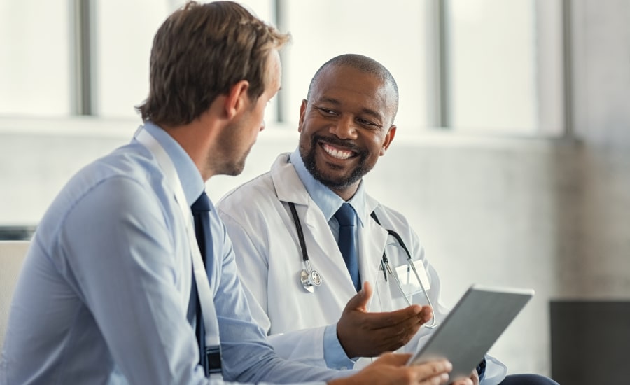 Healthcare professional explaining information to a man in a bright office setting.